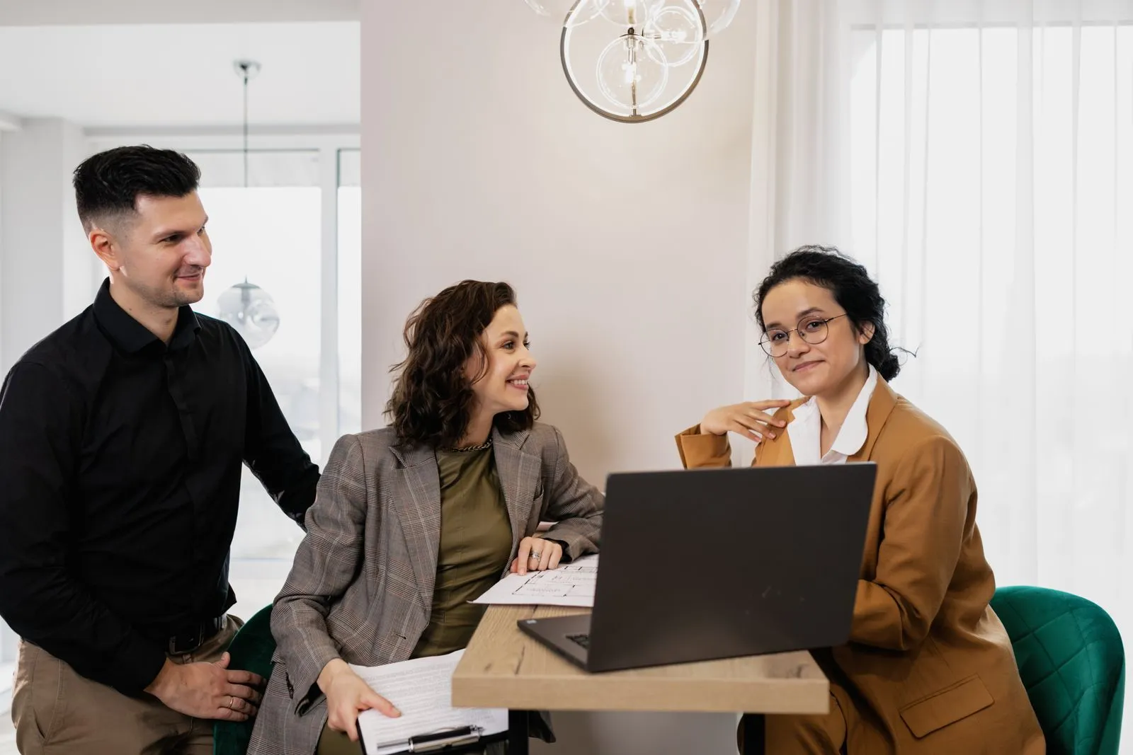 Un couple et une conseillère étudient une offre de prêt sur un ordinateur portable