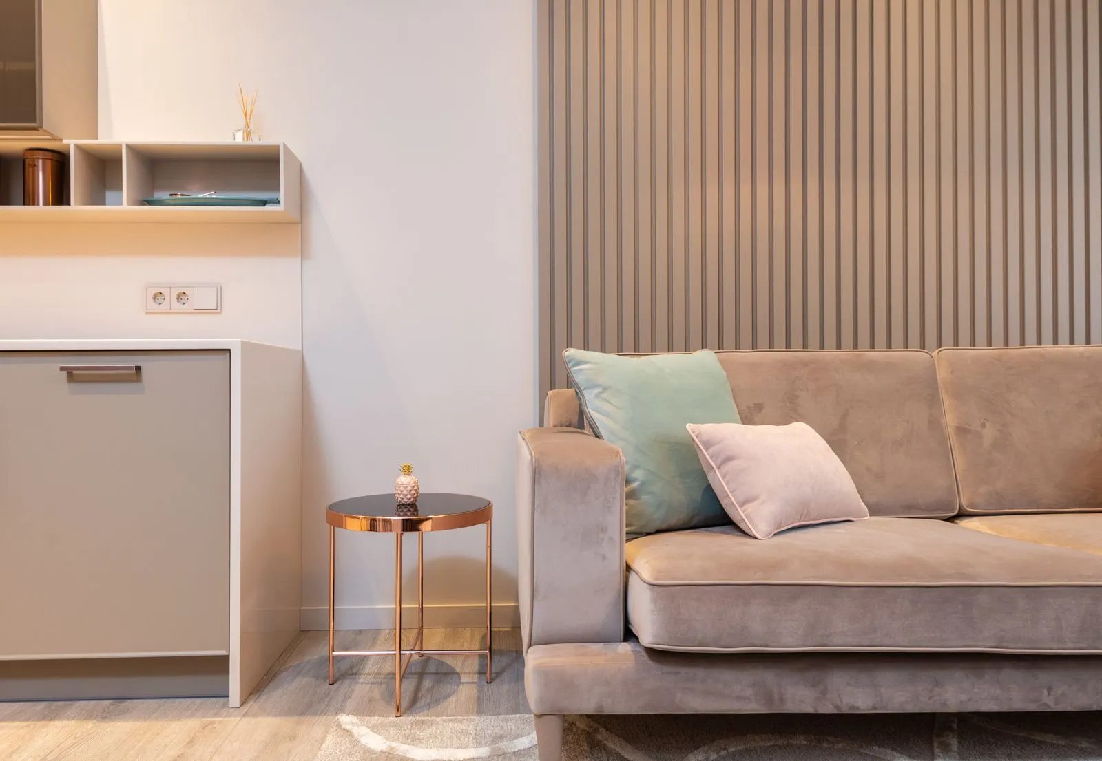Studio meublé avec canapé, petite cuisine et table d'appoint